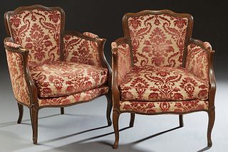 Pair of Louis XV Style Carved Beech Bergeres, 20th c., the arched curved back over upholstered arms and a bowed loose cushion seat, on scrolled cabrio
