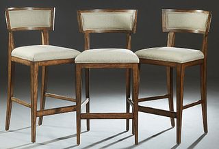 Set of Three Contemporary Carved Mahogany Bar Stools, 20th c., the curved cushioned canted back to a trapezoidal cushioned seat, on tapered square leg