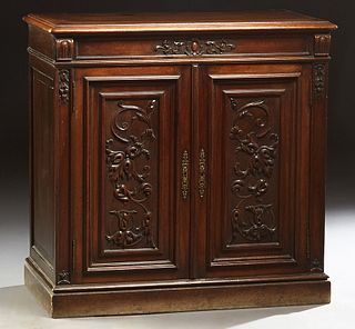 Diminutive French Provincial Henri II Style Carved Walnut Sideboard, c. 1880, the rounded edge top over two cupboard doors with applied carving, flank