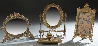 Four Desk Pieces, early 20th c., consisting of a bronze inkwell pen tray; a gilt iron easel picture frame; an iron easel beveled mirror with putti sur