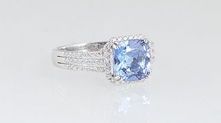 Lady's Platinum Dinner Ring, with a cushion cut 2.38 ct. tanzanite atop a border of tiny round diamonds, the triple split shoulders of the band also m