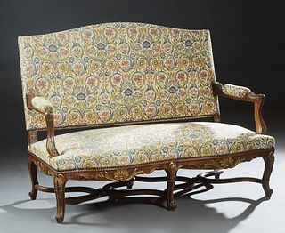 French Louis XV Style Carved Walnut Settee, early 20th c., the arched upholstered canted back over upholstered arms and a serpentine upholstered seat,