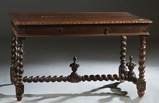 French Henri II Carved Oak Writing Table, c. 1880, the sloping carved edge top over a long frieze drawer, on rope twist trestle legs joined by turned 