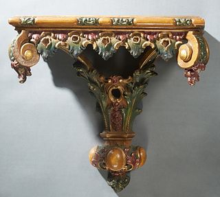 Unusual Polychromed Plaster Bracket Shelf, early 20th c., the stepped top over a relief skirt with scrolled corner supports, to a pierced central supp