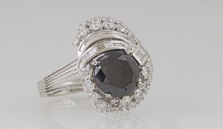Lady's Platinum Dinner Ring, with a round 4.26 ct. black diamond atop a border of round diamonds, with a pierced round and baguette diamond "crown" an