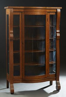 American Carved Oak Curved Glass Curio Cabinet, early 20th c., the bowfront top over a central curved glass door flanked by glass panels and curved gl