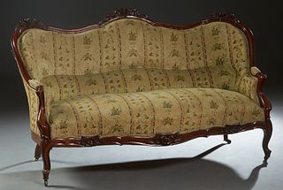 French Louis XV Style Carved Mahogany Settee, late 19th c., the serpentine back with three floral crests over a cushioned back flanked by upholstered 