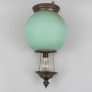 Lámpara de techo. Siglo XX. Elaborada en metal. Para una luz. Con pantalla esférica de vidrio opaco color turquesa.