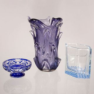 Lote de 3 piezas. SXX En cristal, uno tipo murano y otro de Bohemia. Color azul y morado. Consta de: florero, centro de mesa y depósito