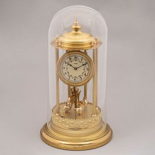Reloj de mesa. Alemania. Siglo XX. Diseño arquitectónico. En latón dorado. Mecanismo de péndulo. Con capelo de vidrio. 43 x 23 cm Ø