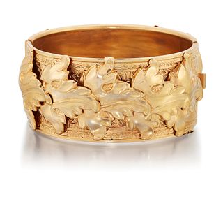 A VICTORIAN BANGLE, applied overlapping vine leaves to a fo