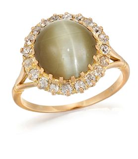 A CAT'S EYE CHRYSOBERYL AND DIAMOND CLUSTER RING, a round c