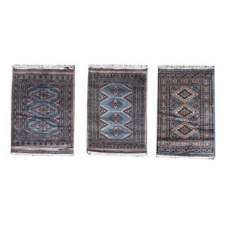 Lote de 3 tapetes, pie de cama. Pakistan, Siglo XX. Estilo bokhara. Elaborados en fibras de lana. Decorados con motivos geométricos.