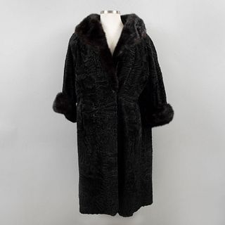 Abrigo largo. Siglo XX. Elaborado en piel de astracán color negro. Con cuello y empuñaduras de piel de mink. Talla aproximada: mediana.