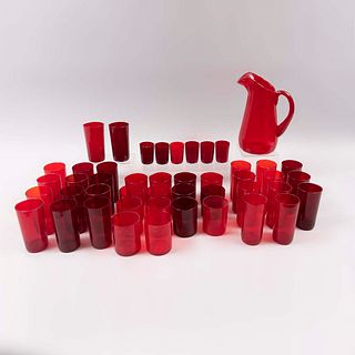 Lote de jarra y vasos. Siglo XX. En vidrio color rojo. Consta de: jarra y 44 vasos de trago largo, trago corto y tequileros. Piezas: 45