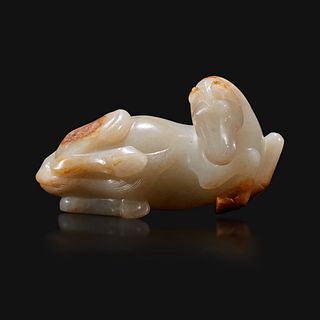 A Chinese russet and greyish-white carved jade figure of a recumbent horse