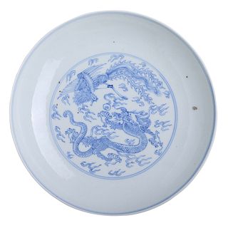A CHINESE BLUE AND WHITE ‘DRAGON AND PHOENIX’ DISH