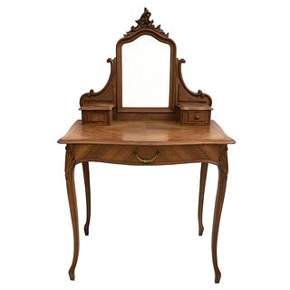 Tocador con espejo.  Siglo XX.  Estilo Luis XV.  En talla de madera de nogal.  Con espejo irregular biselado.