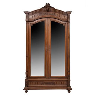 Armario. Francia. Siglo XX. Estilo Enrique II. En talla de madera de nogal. Con 2 puertas abatibles, con espejo.
