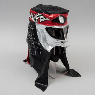 Máscara del luchador Octagón. SXXI. Elaborada en tela sintética en colores negro, rojo y blanco. Firmada por Octagón. Con dedicatoria.