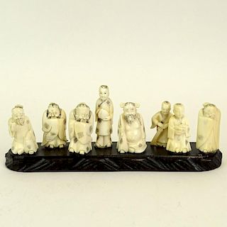 Collection of Eight Japanese Carved Ivory Netsukes on Wood Base