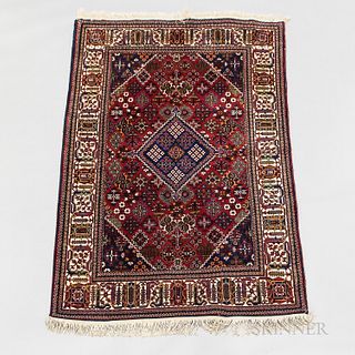 Meshad Carpet, Iran, c. 1930, featuring scattered floral forms on the burgundy red field, 16 ft. 4 in. x 10 ft.