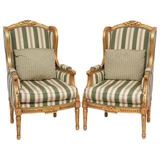 PAIR OF BERGERE ARMCHAIRS 20TH CENTURY Carved and gilded wood, closed backs and linear upholstery 42.1 x 24.4 x 20.8" (107 x 62 x 53 cm)