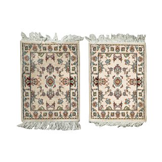 Par de tapetes pie de cama. Turquía, sXXI. Elaborados en fibras de dralón. Decorados con elementos florales y orgánicos. 72 x 50 cm
