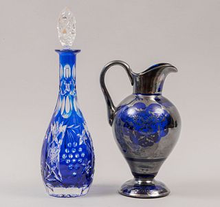 Licorera y jarra. Siglo XX. Elaboradas en cristal de Bohemia y vidrio. Color azul. Decoradas con elementos facetados.
