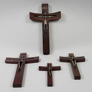 Lote de 4 crucifijos. Siglo XX. Cruz en talla de madera y Cristos en plata. 37 cm altura.