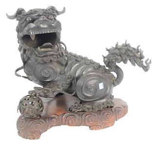 Large Chinese Bronze Foo Lion or Dog Censor on original carved stand having left paw raised on ball, possibly Qing Dynasty or Ming, 18th century, heig