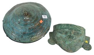 Two Metal Mayan-Style Items to include a face mask, height 9 inches, along with a disc in the form of a shield, diameter 18 inches.