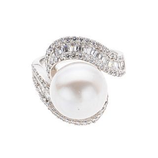Anillo con perla y simulantes en plata .925. 1 perla cultivada tono gris de 11 mm. Talla: 5 1/2. Peso: 7.5 g.