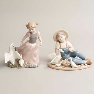 Lote de 2 figuras decorativas. España. SXX. En porcelana Nadal. Acabado brillante. Consta de: niña con patos y niño con patos y flores.