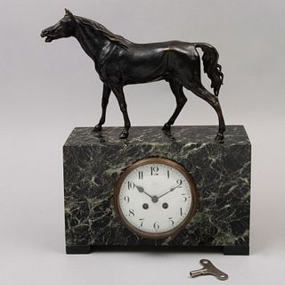 Reloj de chimenea. Siglo XX. Elaborado en bronce y mármol verde jaspeado. Mecanismo de cuerda. Decorado con caballo.