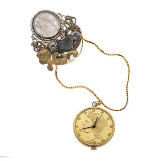 Reloj prendedor de bolsillo en acero dorado. . Movimiento manual. Carátula con imitación de moneda. (falta cristal). Peso: 48g.