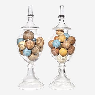 Two uncolored glass apothecary jars filled with baseballs 20th century