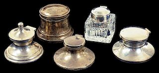 ONE SILVER MOUNTED GLASS AND FOUR SILVER INKWELLS, ALL BUT THE FIRST OF CAPSTAN FORM, VARIOUS MAKERS