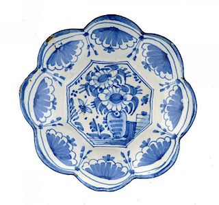 A CONTINENTAL FAIENCE DISH OR BUCKELPLATTE,  painted in cobalt with a vase of flowers and