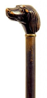 A 19TH CENTURY EBONISED WALKING CANE, THE CARVED HOUND'S HEAD HANDLE WITH GLASS EYES