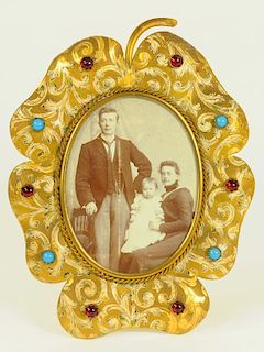 A 19TH CENTURY PAINTED AND GILT BRASS LEAF SHAPED PHOTOGRAPH FRAME STUDDED WITH COLOURED GLASS '