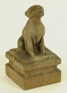 A CARVED WOOD SCULPTURE OF A SEATED DOG