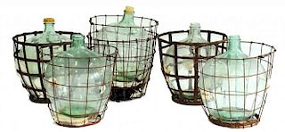 FIVE GLASS CARBOYS IN WIRE CARRIERS