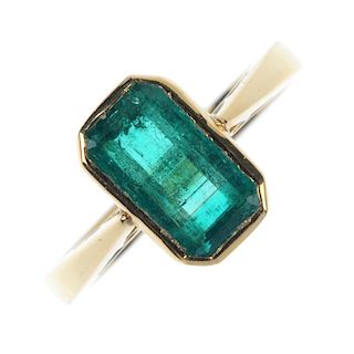 An 18ct gold emerald single-stone ring. The rectangular-shape emerald collet, to the tapered shoulde