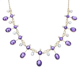 An early 20th century gold amethyst and aquamarine fringe necklace. Designed as a graduated series o