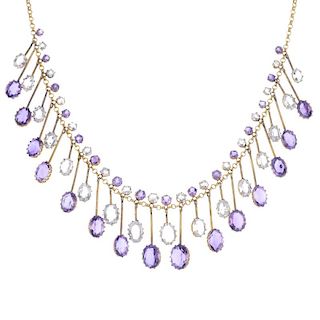 An amethyst and topaz fringe necklace. Designed as a series of graduated oval-shape amethyst and col