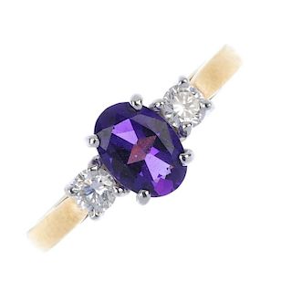 An 18ct gold amethyst and diamond three-stone ring. The oval-shape amethyst, with brilliant-cut diam
