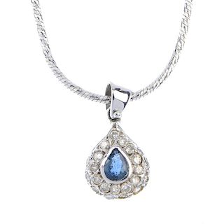 A sapphire and diamond cluster pendant. The pear-shape sapphire, within a pave-set diamond surround,