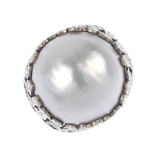 A mabe pearl dress ring. The mabe pearl, raised with an openwork textured surround and shoulders, to
