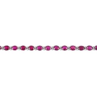 An 18ct gold ruby and diamond line bracelet. The oval-shape ruby line, with brilliant-cut diamond do